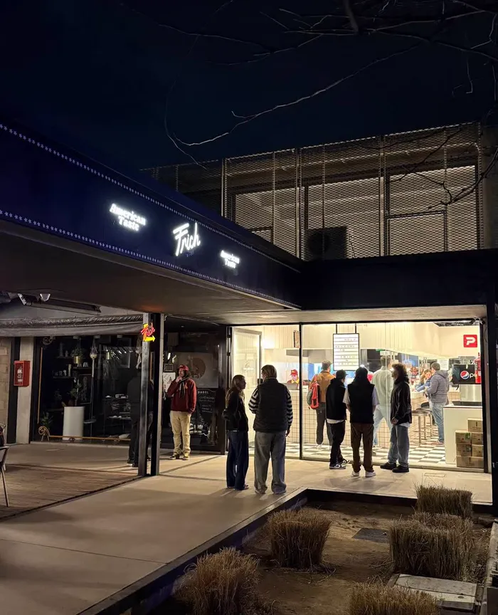 El local de Valle Escondido de noche, con gente esperando en la puerta